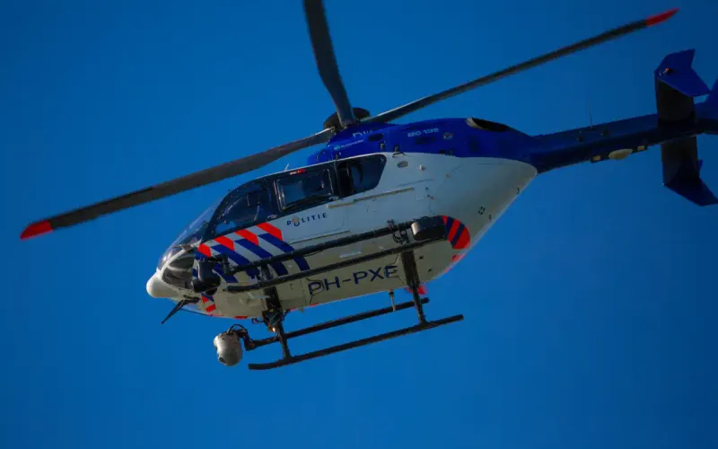 Politiehelikopter PH-PXE Eurocopter EC135 P2+ (POLICE05) tijdens politie-inzet boven Nederlandse stad